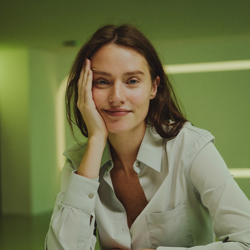 White woman in a smart casual blouse, burnt out by a toxic workplace