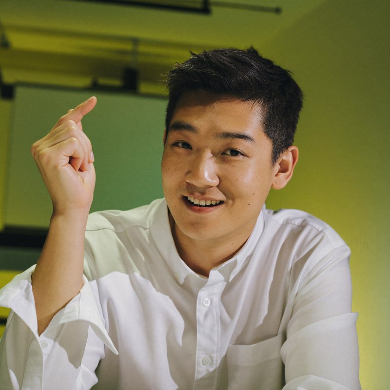East Asian man in a casual button-up, founder with early revenue